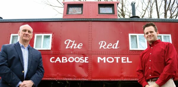 Red Caboose with white painted words reading: The Red Caboose Hotel